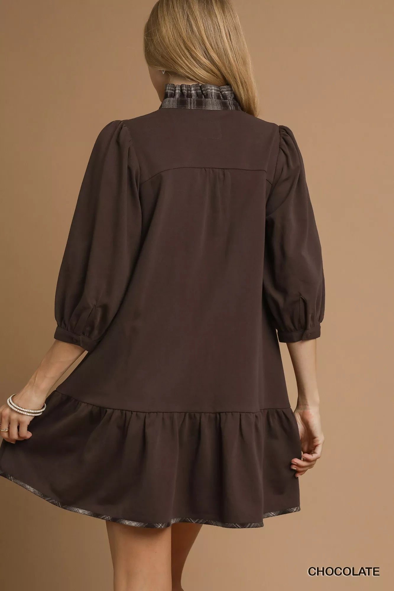 Back view of women's brown French terry dress with plaid collar and ruffle hem.