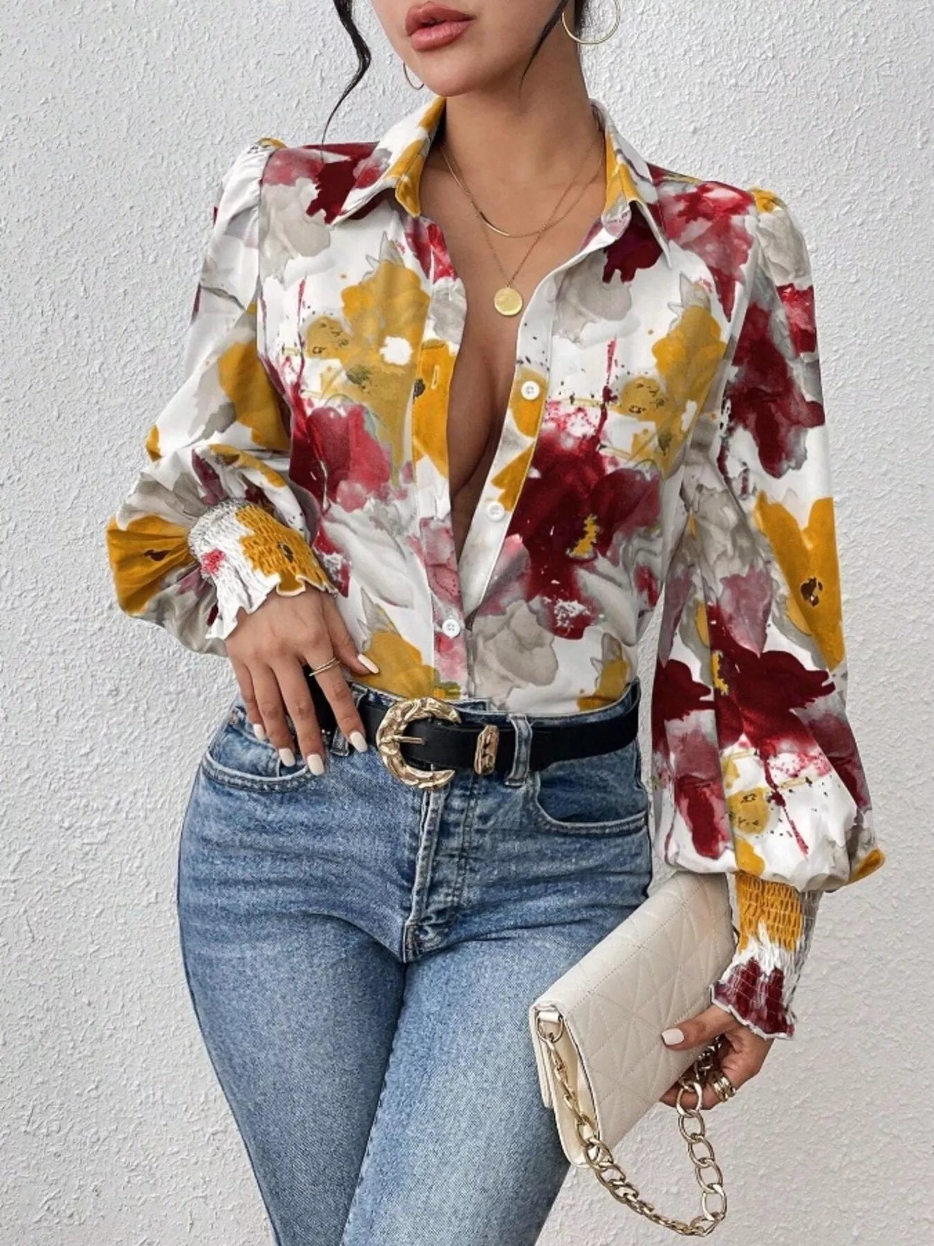A printed button-up shirt with lantern sleeves made from a polyester blend.