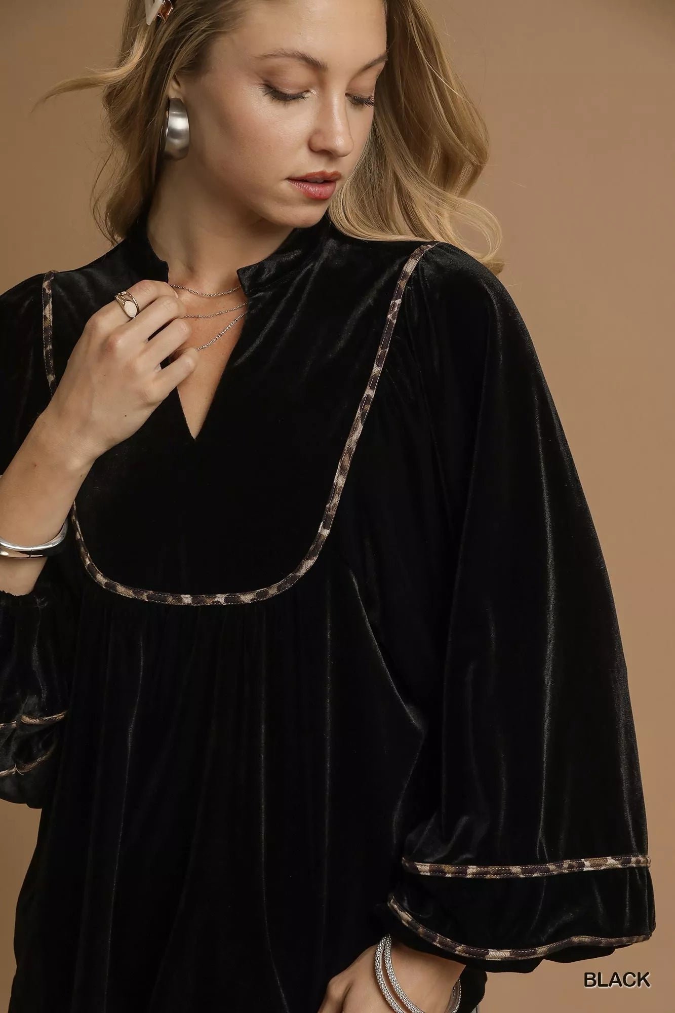 Black velvet long-sleeve blouse with contrast trim on a model.