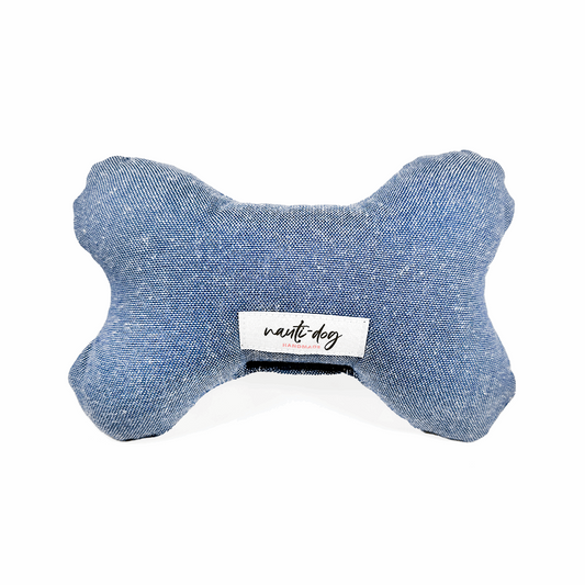 Blue chambray stuffed bone-shaped dog toy with squeaker and Nauti Dog label.