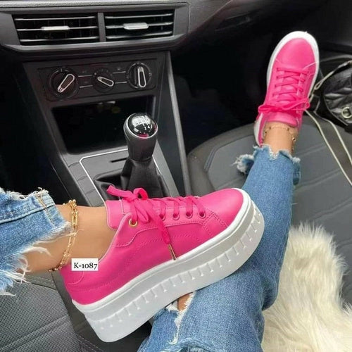 Women's tan leather platform sneakers with white soles and laces on a model.