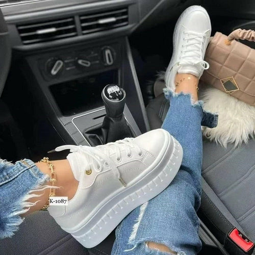 Tan leather platform sneakers for women with thick soles and laces, shown on feet in a car.