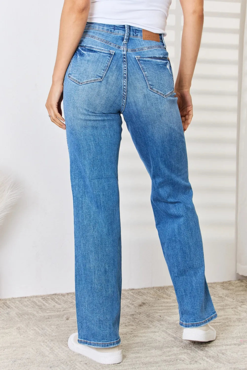 Rear view of Judy Blue high-waist distressed straight-leg jeans on a model.