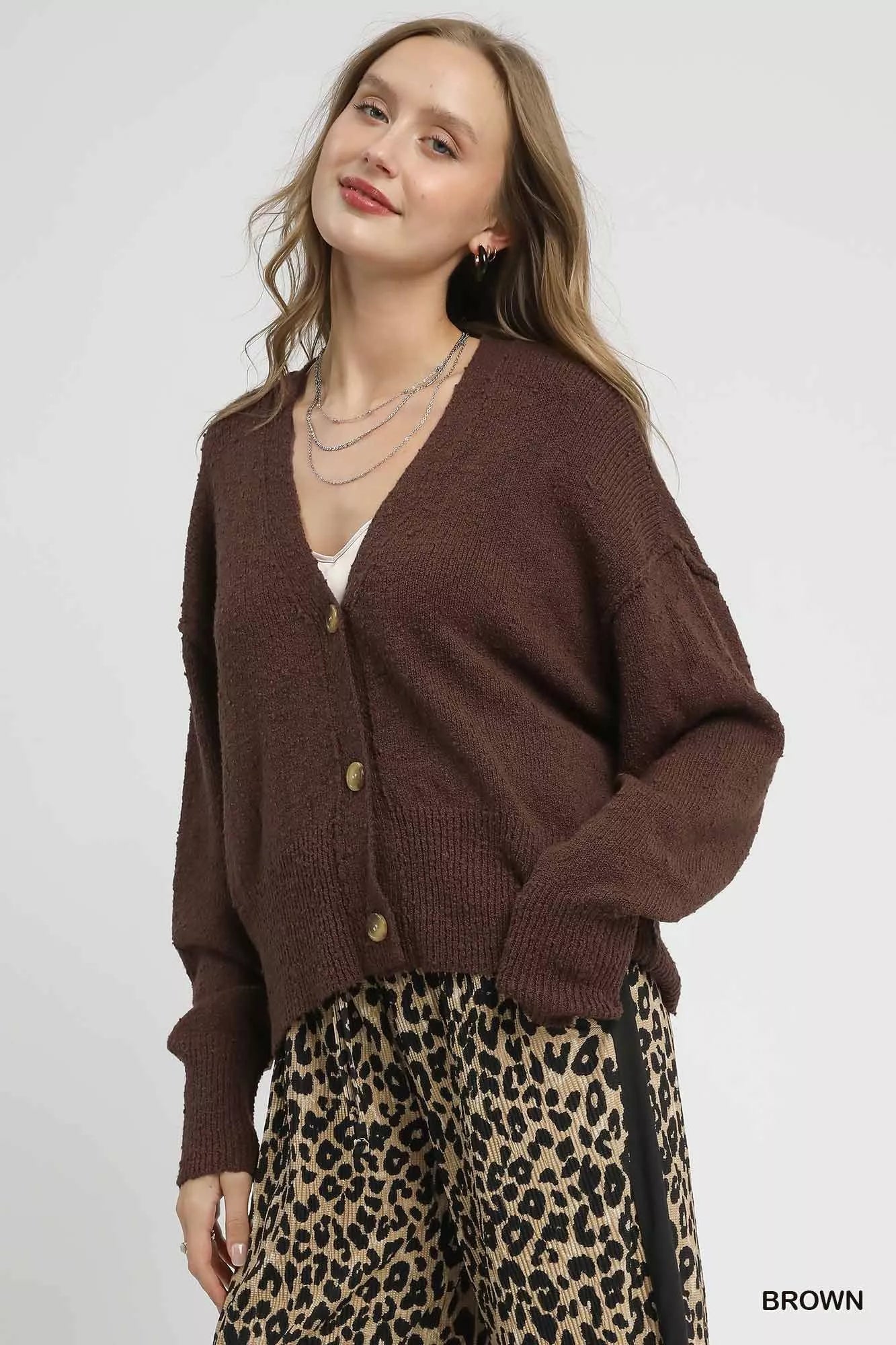 Woman modeling hemlock brown button-front V-neck knit cardigan with long sleeves.
