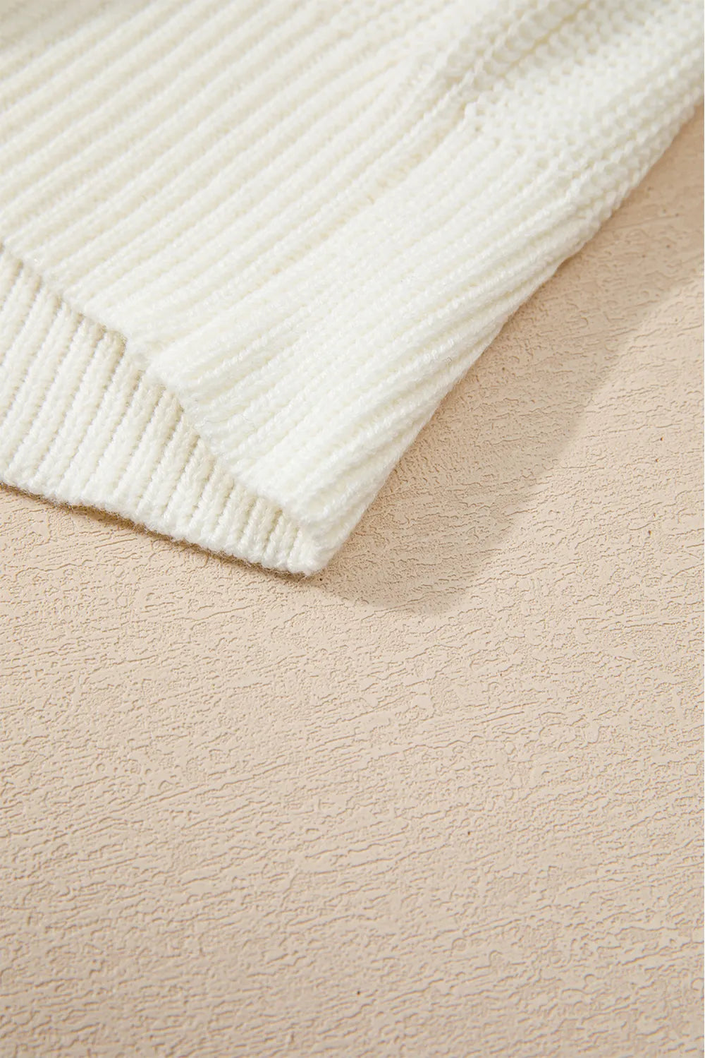 Cream acrylic cotton round neck sweater with ribbed texture.