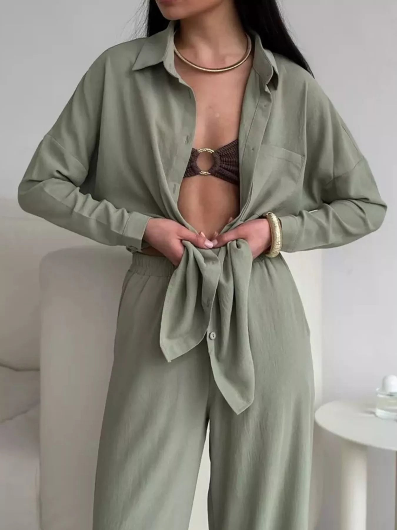 Woman modeling green two-piece button-down shirt and pants set with pockets and slight stretch.