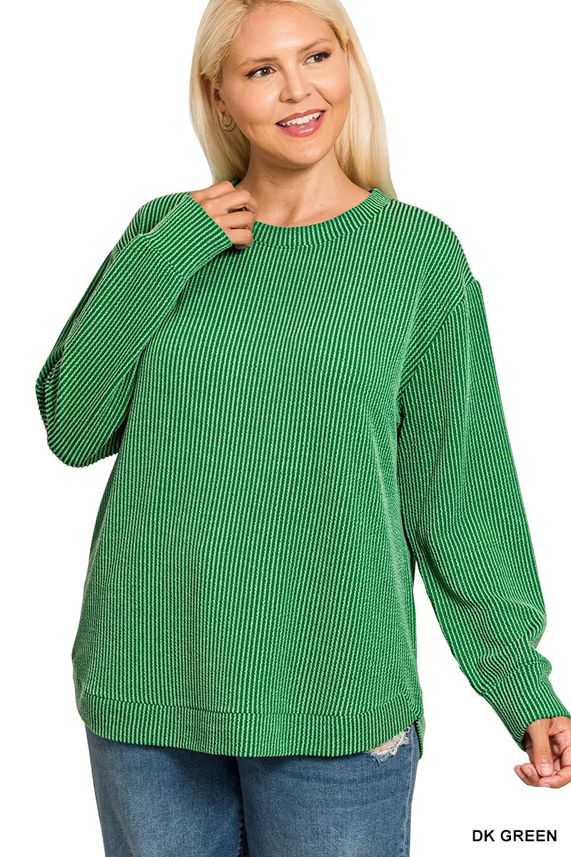 Plus-size woman modeling a dark green raised rib round neck long sleeve top.
