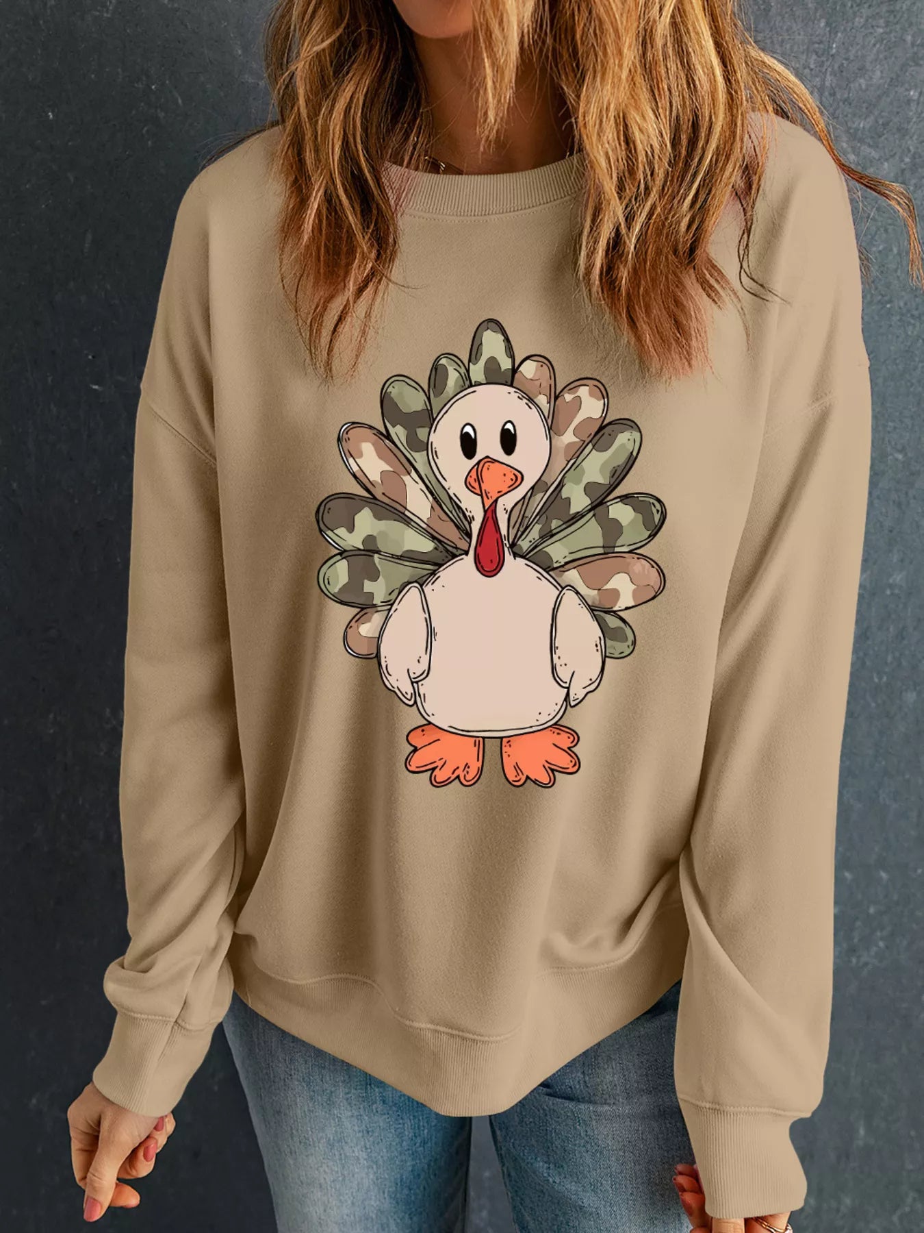 Camouflage Thanksgiving turkey graphic on a beige crewneck sweatshirt.