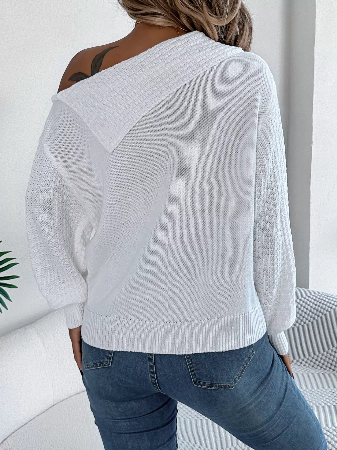 Cream cable knit off-shoulder sweater made of slightly stretchy acrylic fabric.