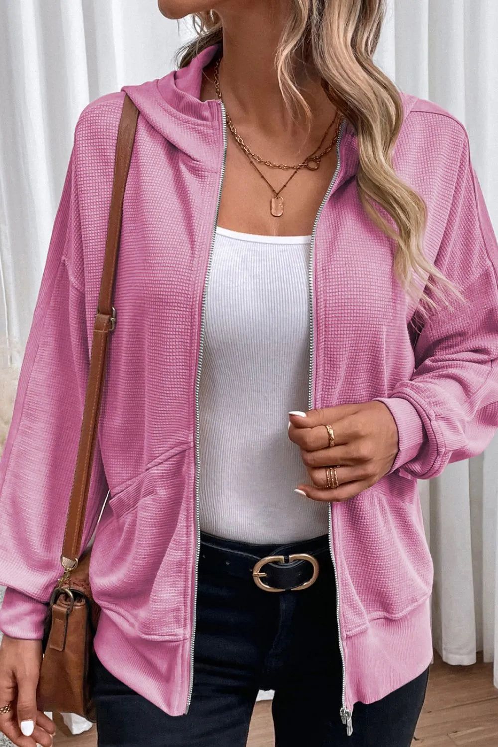 Soft pink waffle-knit zip-up hooded jacket on a model.