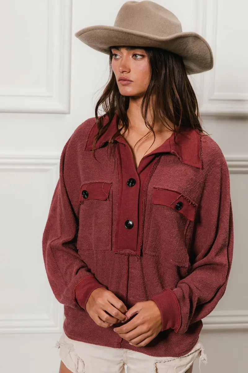 Oversized maroon French terry collared top with buttons and pockets, modeled on a woman.