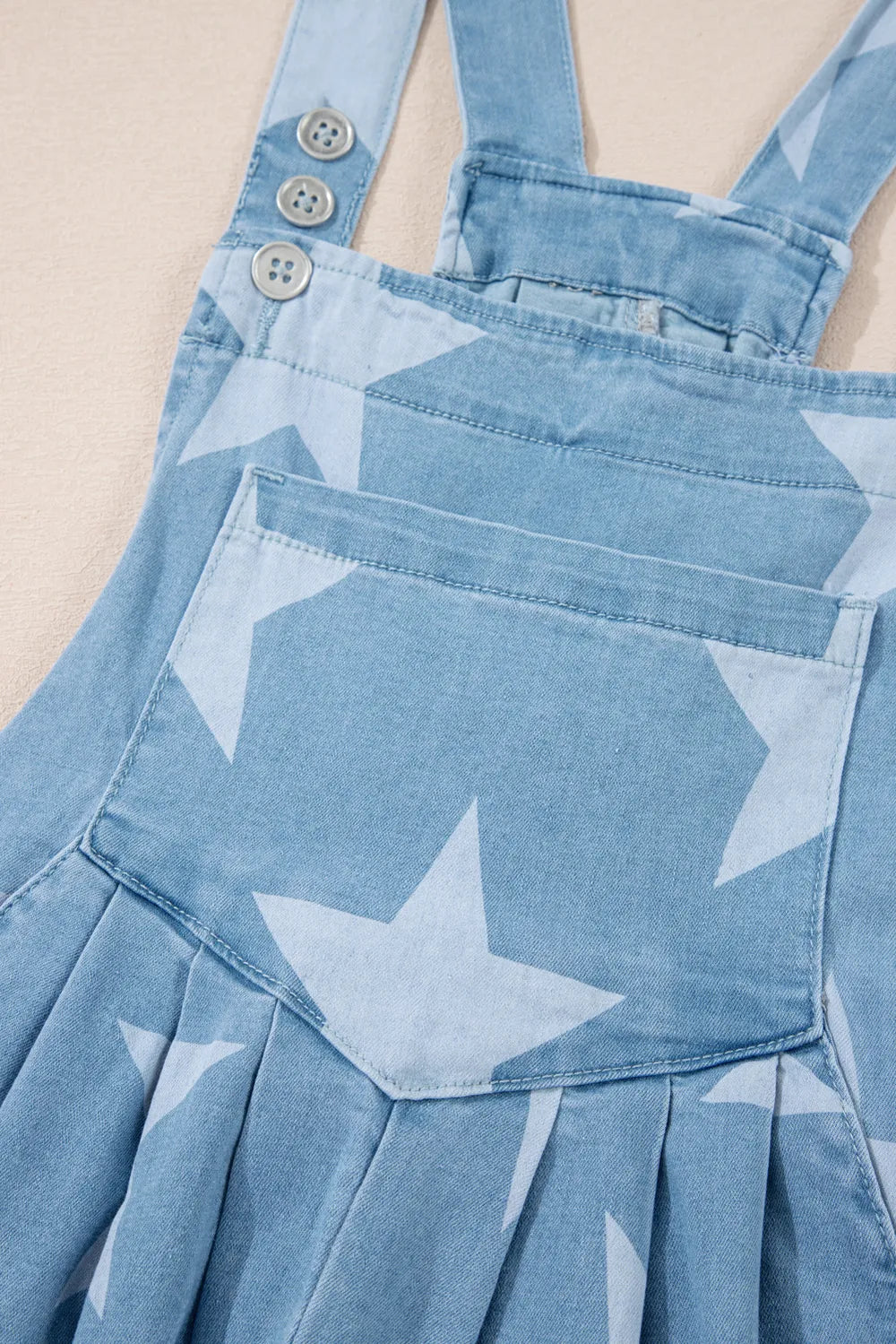 Denim overalls with star print, square neck, cotton blend fabric, and front pockets.