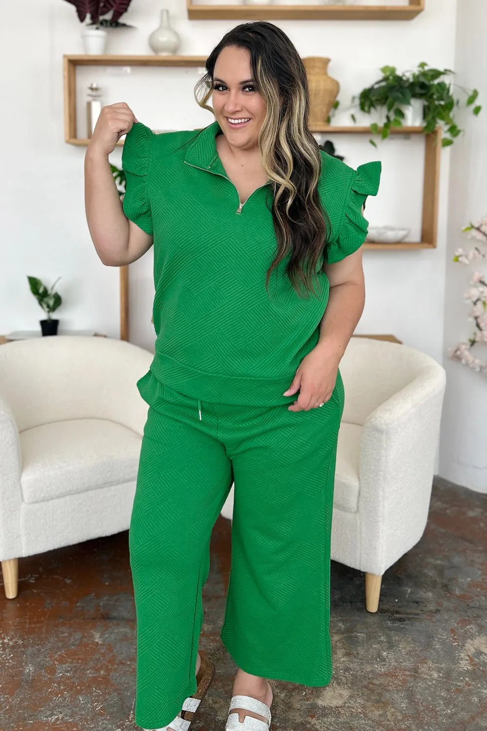 Woman modeling a textured green ruffle short sleeve top and wide leg pants set.