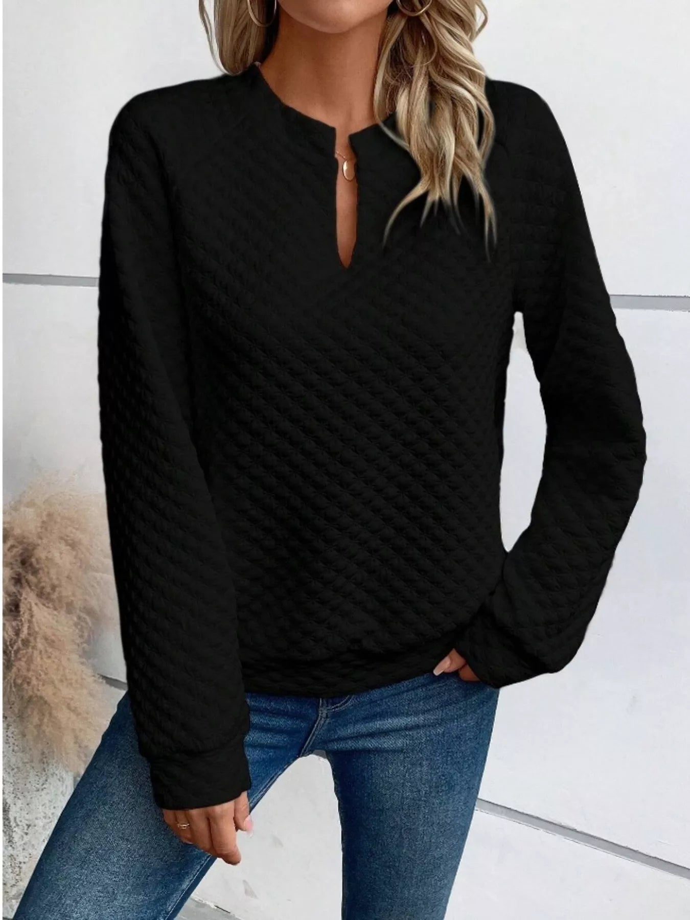 Gray textured sweatshirt with notched raglan sleeves and a relaxed fit.