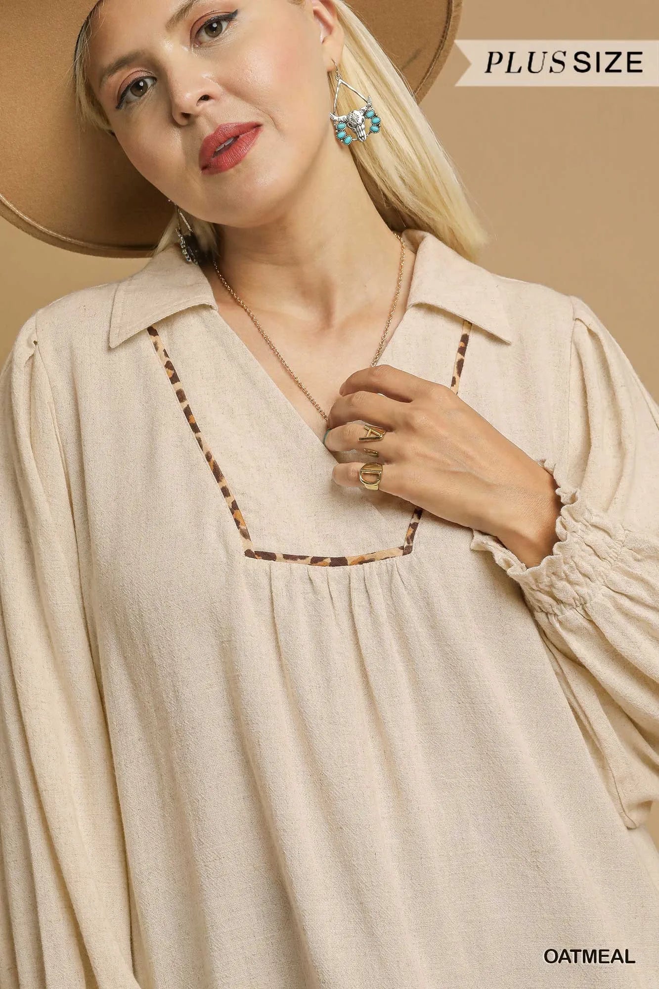 Woman modeling plus-size oatmeal linen scallop hem blouse with contrast trim.