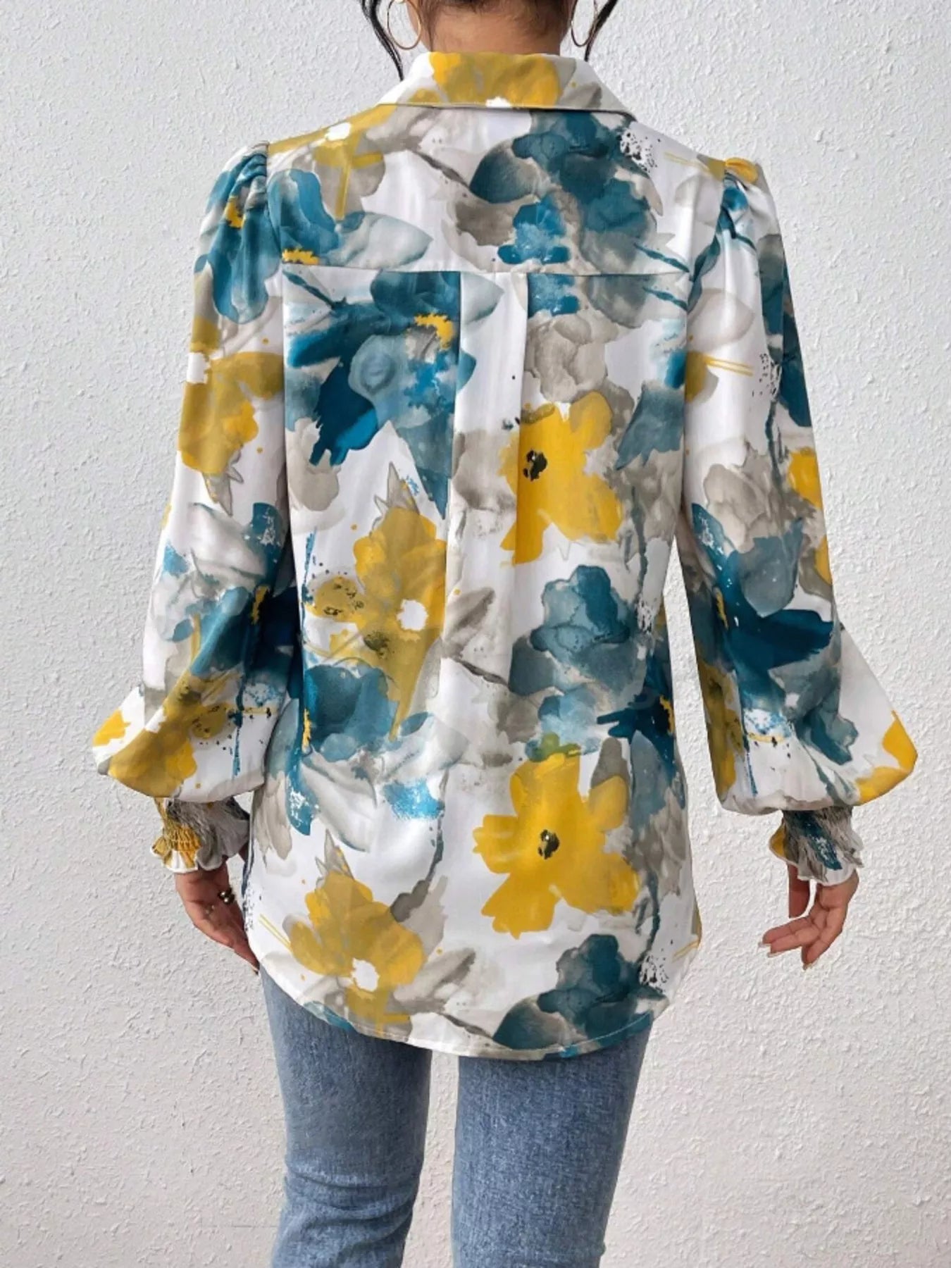 A printed button-up shirt with lantern sleeves, made from a polyester blend.