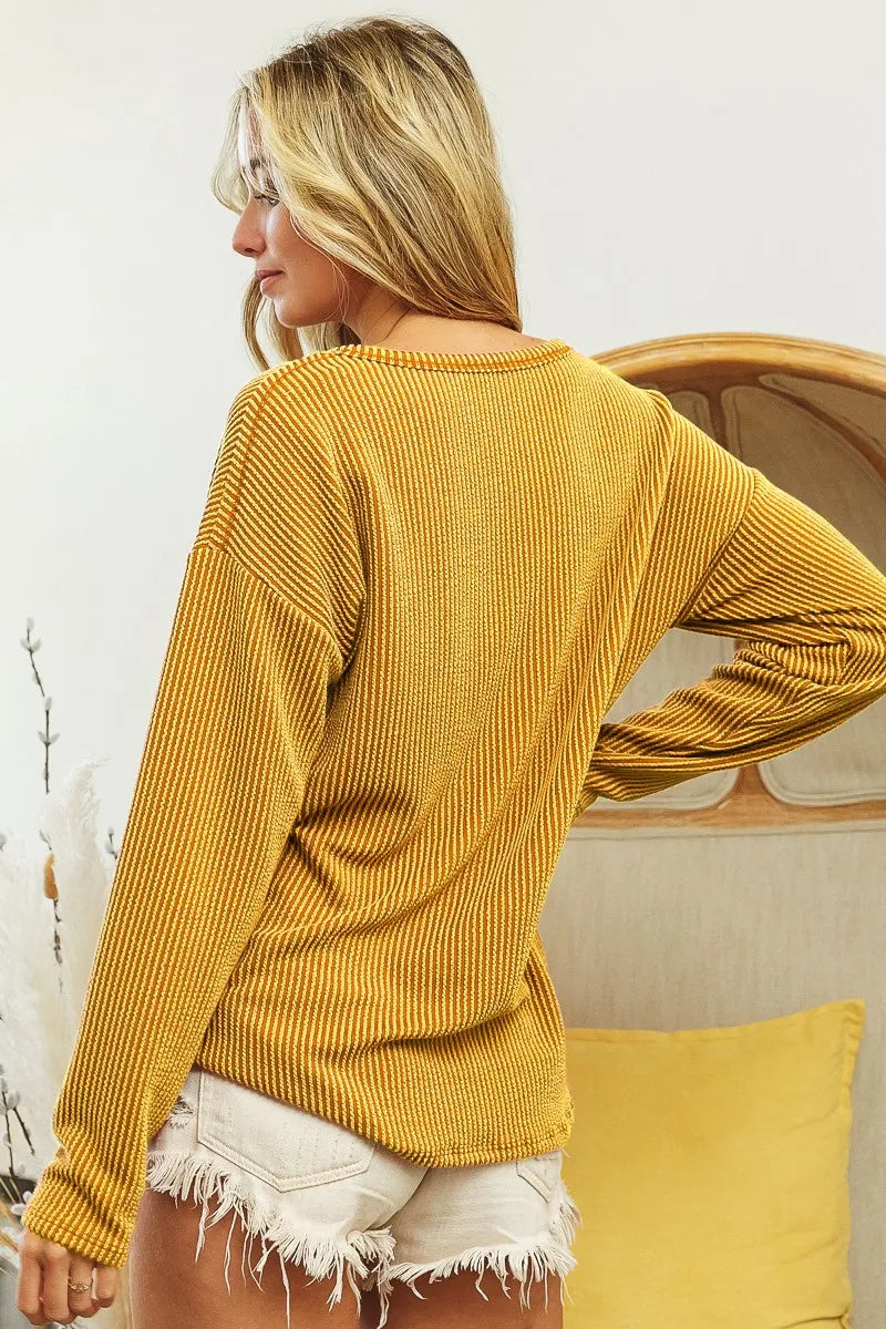 Two tone ribbed notch neck top with patch pocket and contrasting colors in a wavy design
