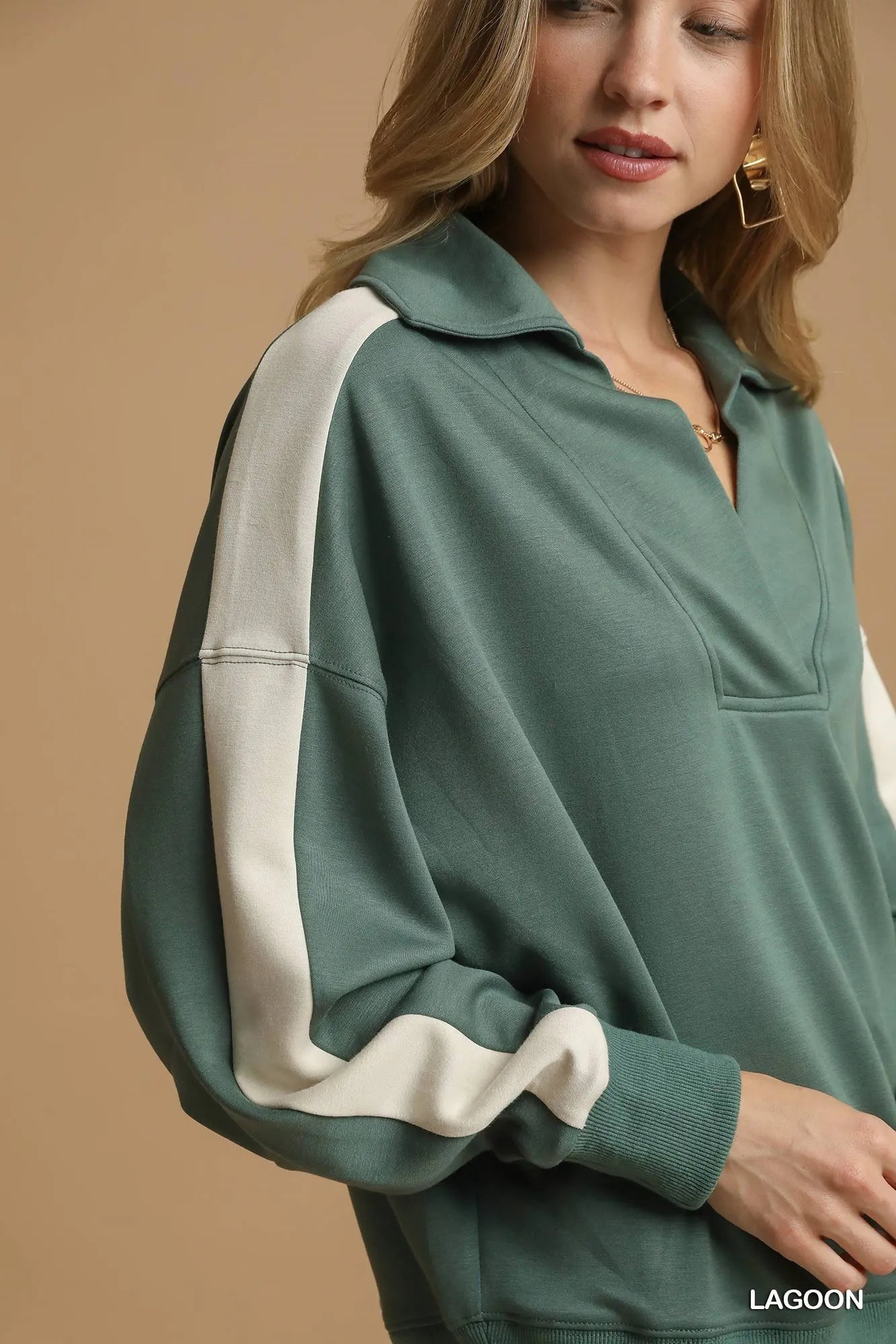 Sage green long-sleeve sweatshirt with white contrast stripes on sleeves and quarter-zip collar.