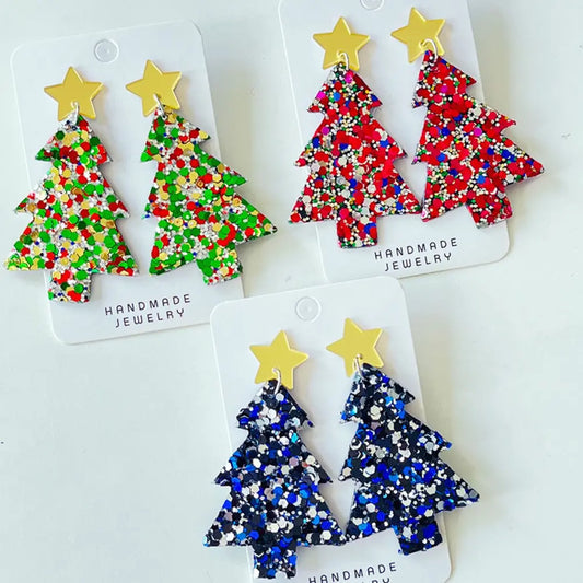 Acrylic dangle earrings shaped as colorful glittery Christmas trees with gold stars.