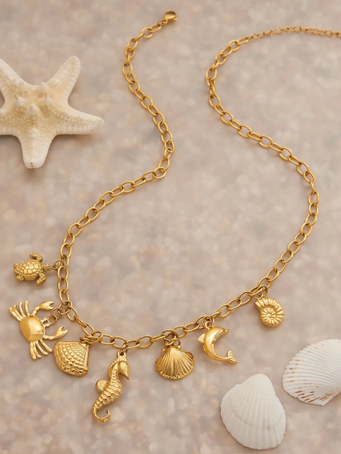 18K gold-plated stainless steel ocean theme necklace with shell, seahorse, crab, and starfish charms.