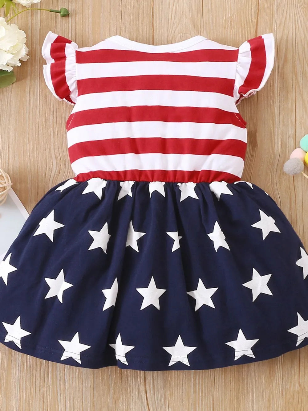 Ruffled cap sleeve dress with striped stars pattern in a polyester blend fabric.
