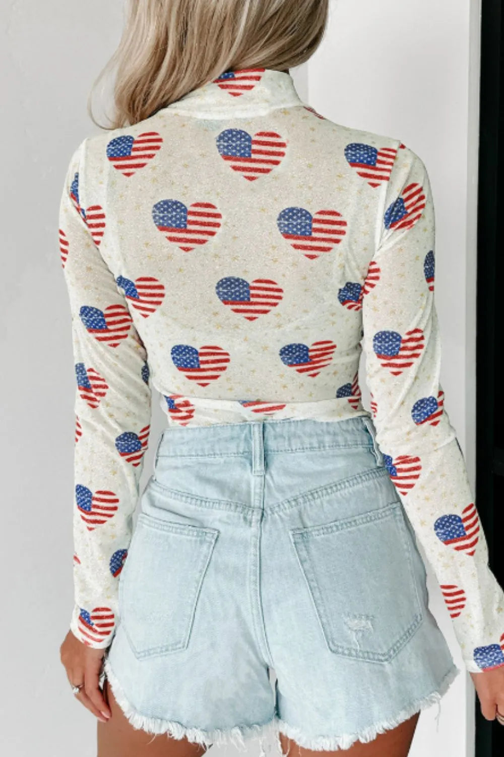 Sheer mock neck long sleeve bodysuit with US flag heart design and slight stretch.