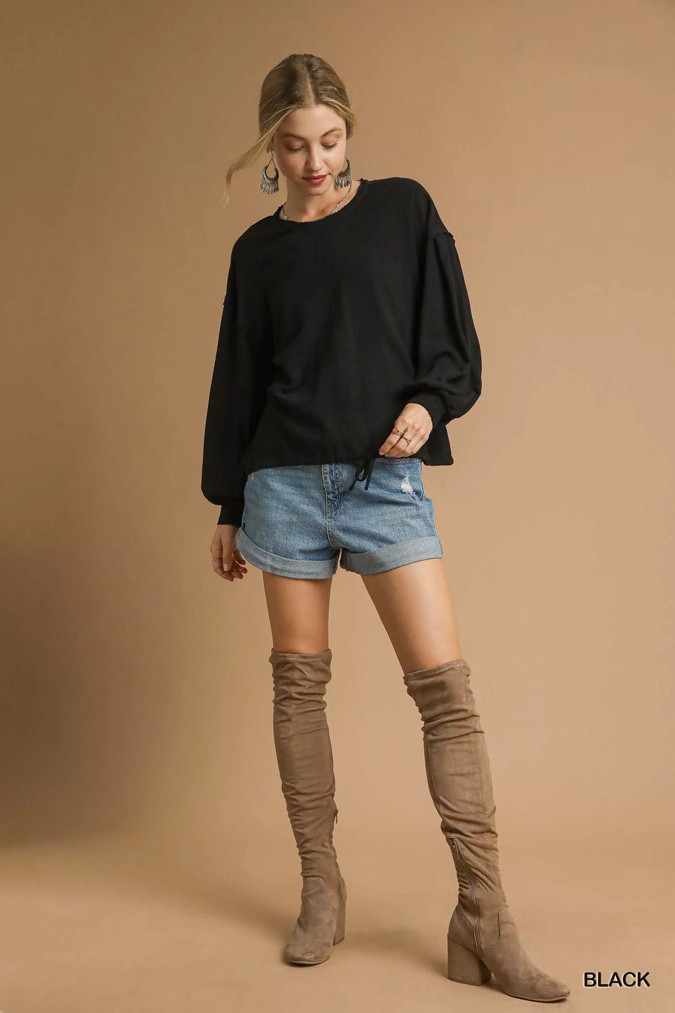 Woman modeling plus-size Umgee linen long sleeve drawstring top in black.