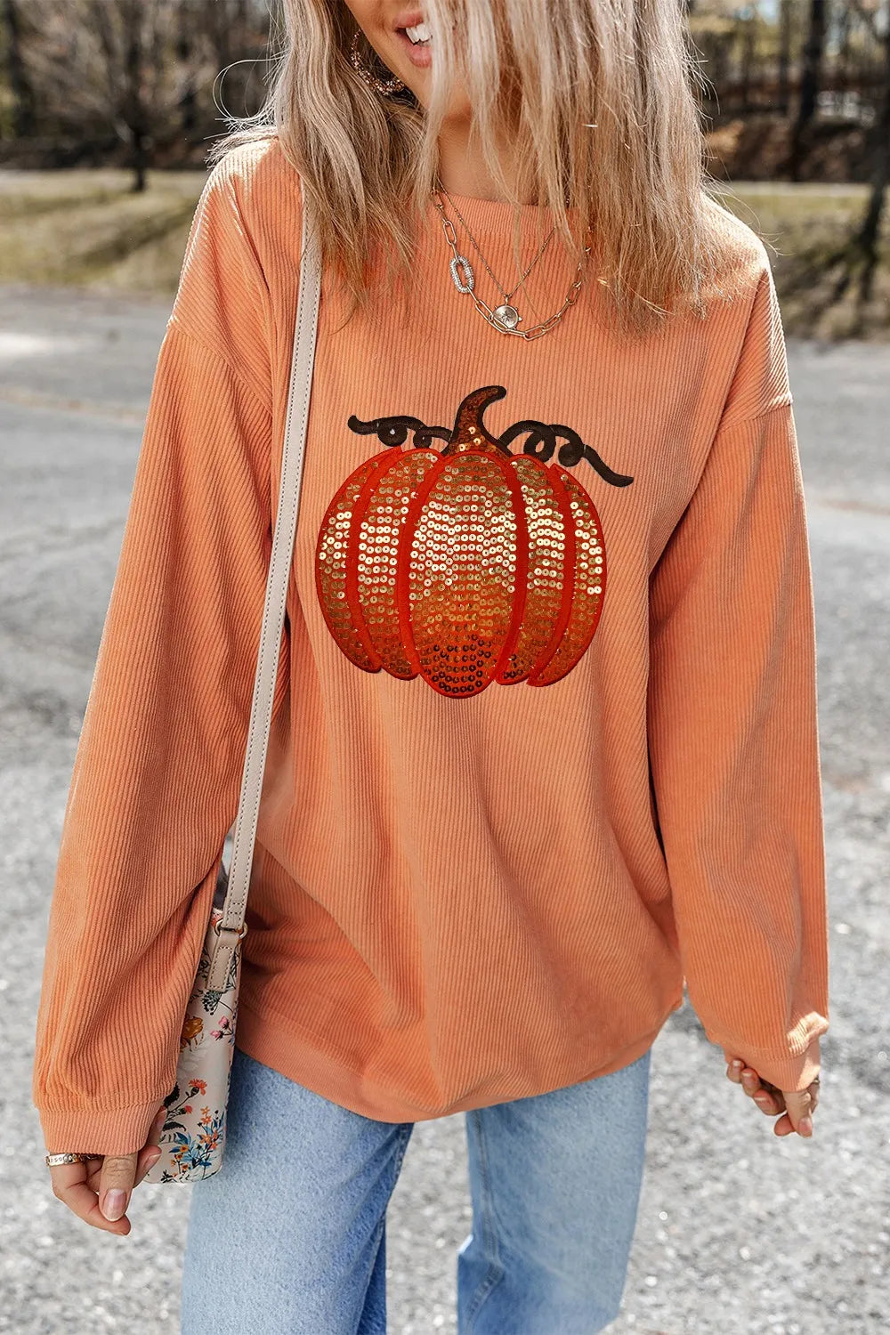 Long sleeve round neck sweatshirt with a pumpkin sequin design and cozy fit.