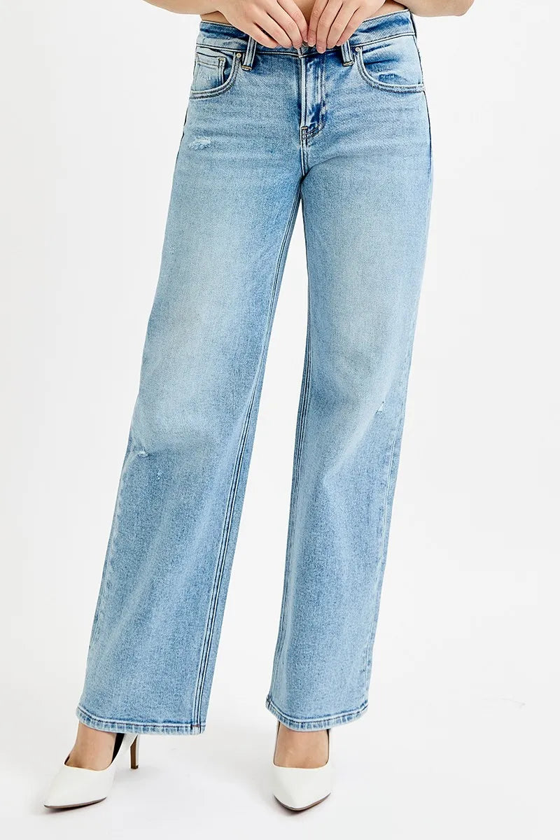Light wash wide leg flare boyfriend jeans in plus size, shown on model with white heels.