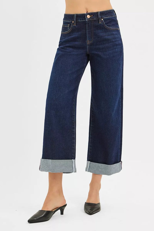 Mid-rise ankle wide-leg jeans in dark wash with rolled cuffs, modeled on a woman.