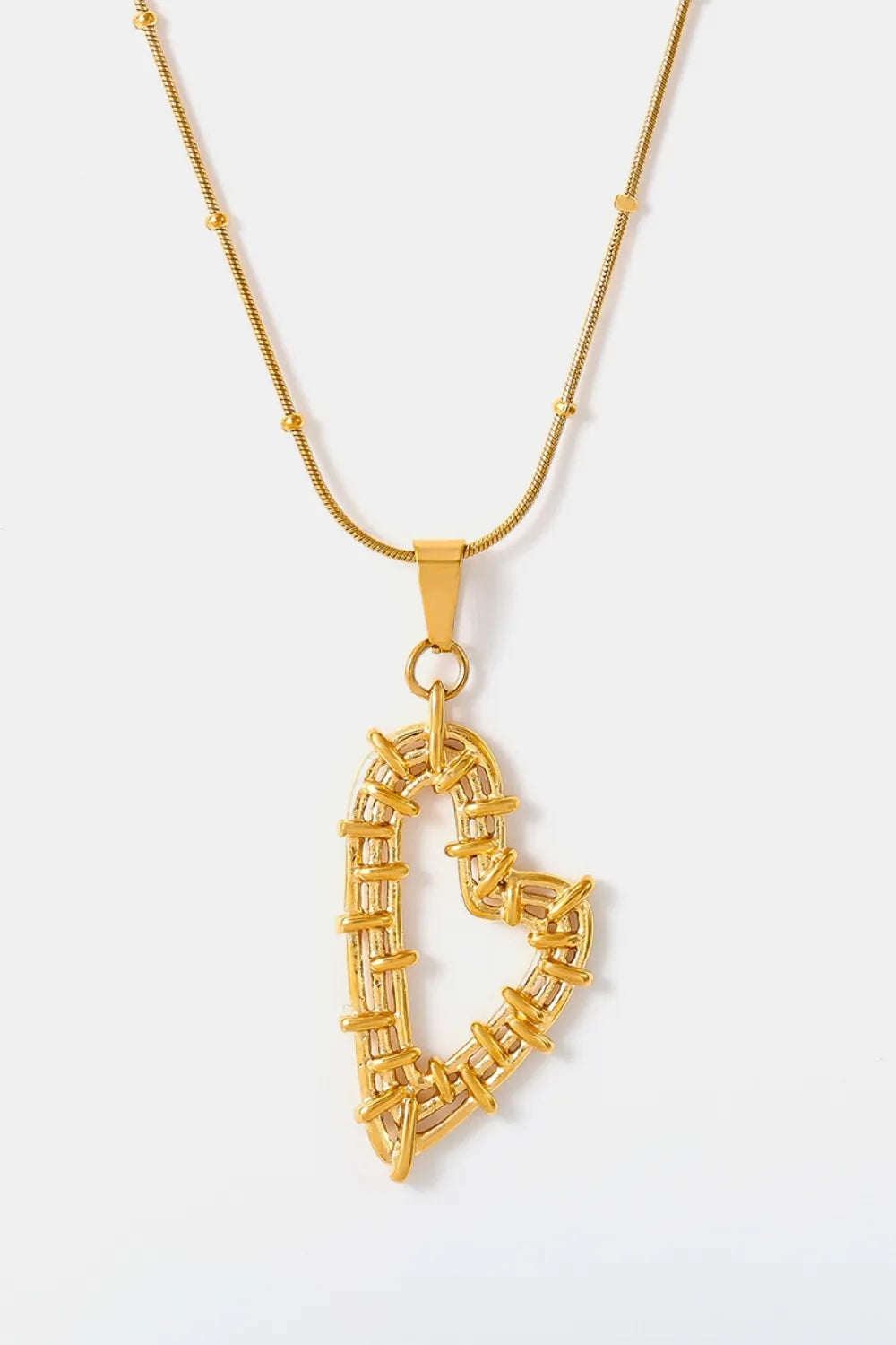 Gold-plated stainless steel necklace with openwork heart pendant and matching stud earrings.