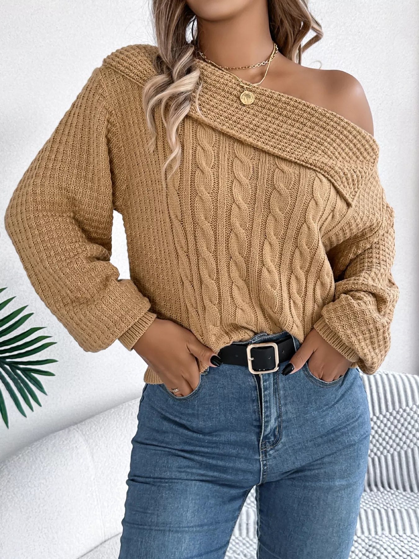 Beige cable knit off-shoulder sweater made of slightly stretchy acrylic fabric.