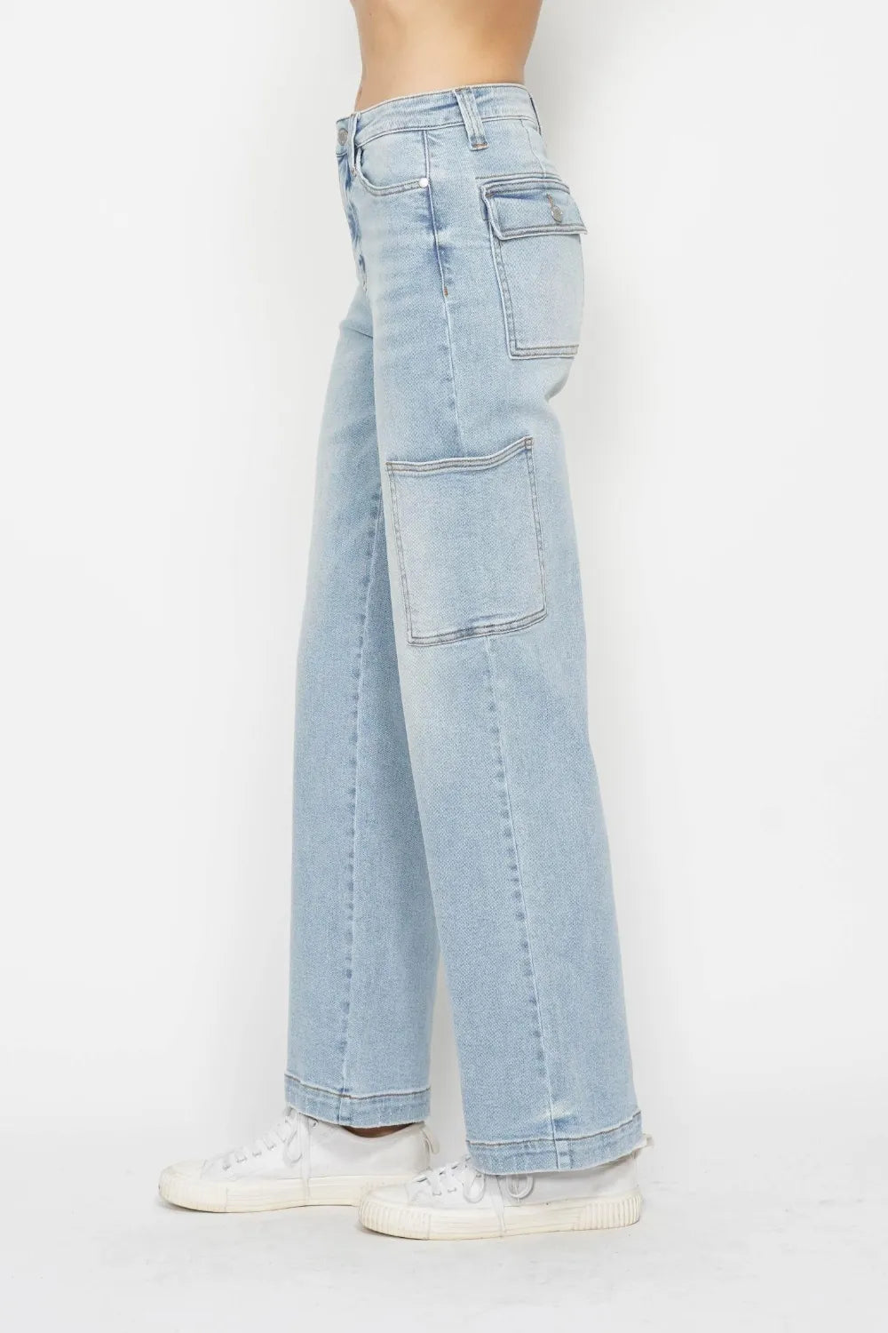 High-waist straight-leg cargo jeans in light wash with multiple pockets, model side view.