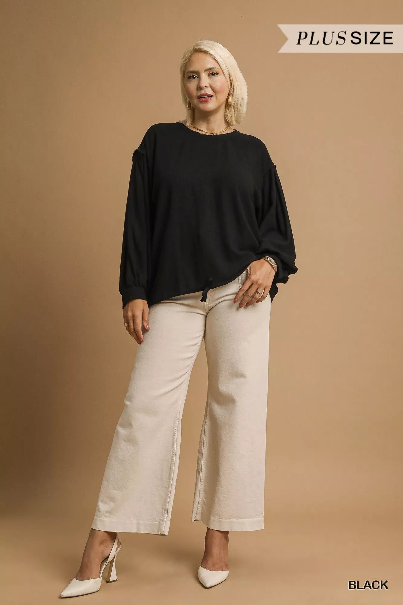 Plus size black linen long sleeve drawstring top on a model with wide-leg pants.