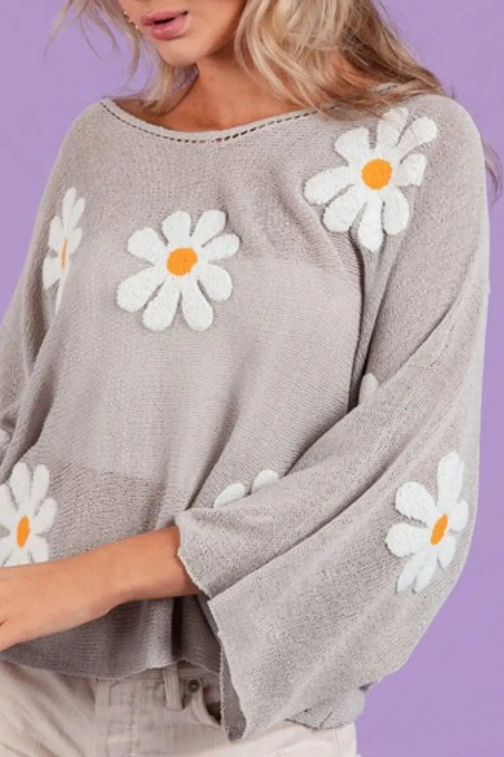 Loose fit knit top in gray with white daisy embroidery and bell sleeves.