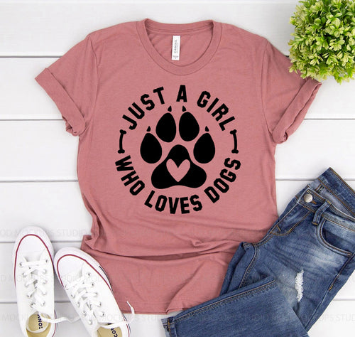 Pink Bella Canvas T-shirt with black "Just A Girl Who Loves Dogs" text and paw print graphic.