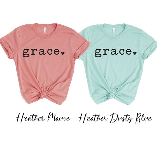 Two unisex Grace t-shirts in heather mauve and dusty blue, made of soft cotton.