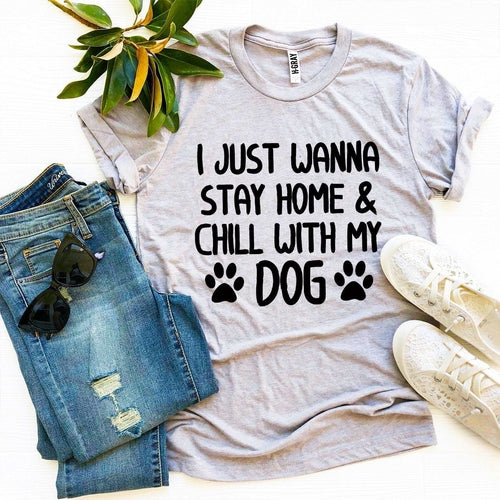 Light gray cotton t-shirt with "I just wanna stay home & chill with my dog" print, styled with jeans, sneakers, and greenery.