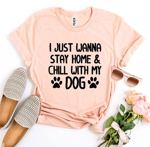 Pink soft cotton t-shirt with graphic text "I just wanna stay home & chill with my dog" and paw prints.