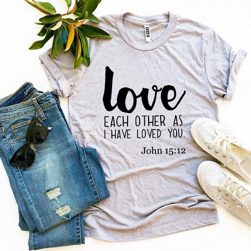Mauve Bella Canvas T-shirt with "Love Each Other as I have Loved You - John 15:12" print, styled with jeans and sneakers.