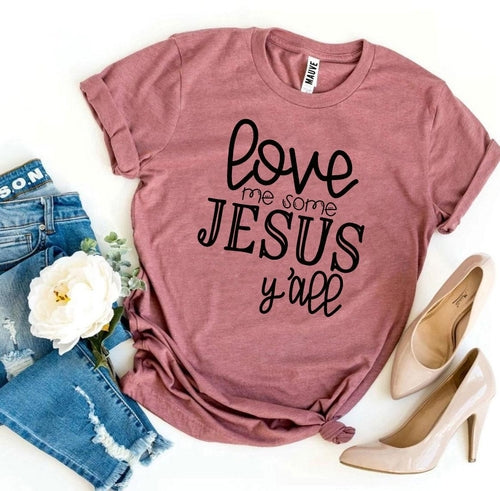 Pink Bella Canvas cotton t-shirt with "Love Me Some Jesus Y'all" text, styled with jeans and heels.