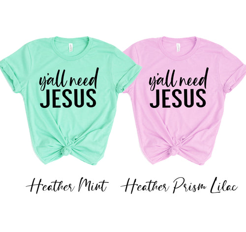 Two unisex t-shirts with "Y'all Need Jesus" text, one in heather mint and one in heather prism lilac.