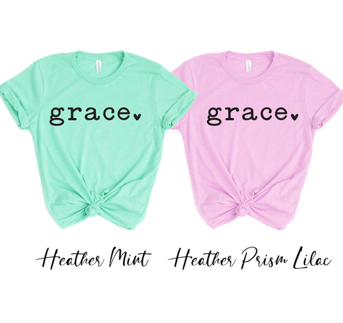 Two unisex Grace t-shirts, one in feather mint and one in heather prism lilac, made of soft cotton.