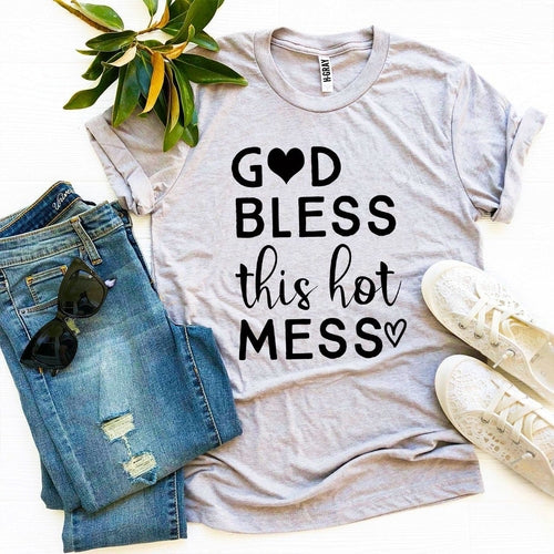 Gray Bella Canvas cotton t-shirt with "God Bless this Hot Mess" text, styled with jeans, sunglasses, and white sneakers.