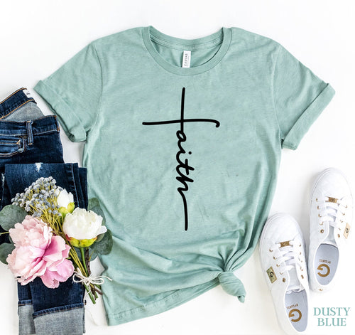 Dusty blue Bella Canvas T-shirt with black "Faith" text and cross design, styled with jeans and sneakers.