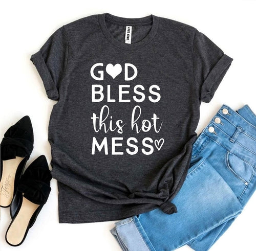 Gray Bella Canvas cotton t-shirt with "God Bless this Hot Mess" text, paired with blue jeans and black heels.