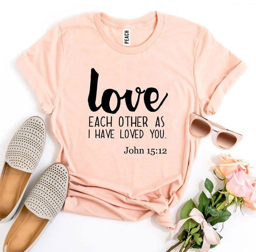 Mauve Bella Canvas T-shirt with "Love each other as I have loved you. John 15:12" print, styled with sunglasses and roses.