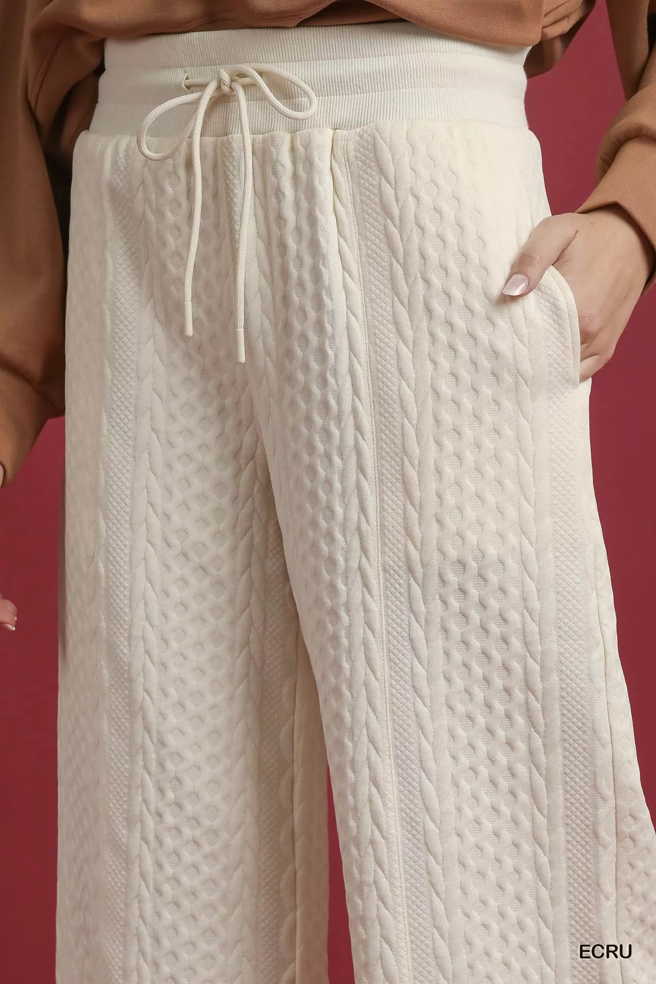 White cable knit textured wide leg pants with drawstring waist and side pockets.