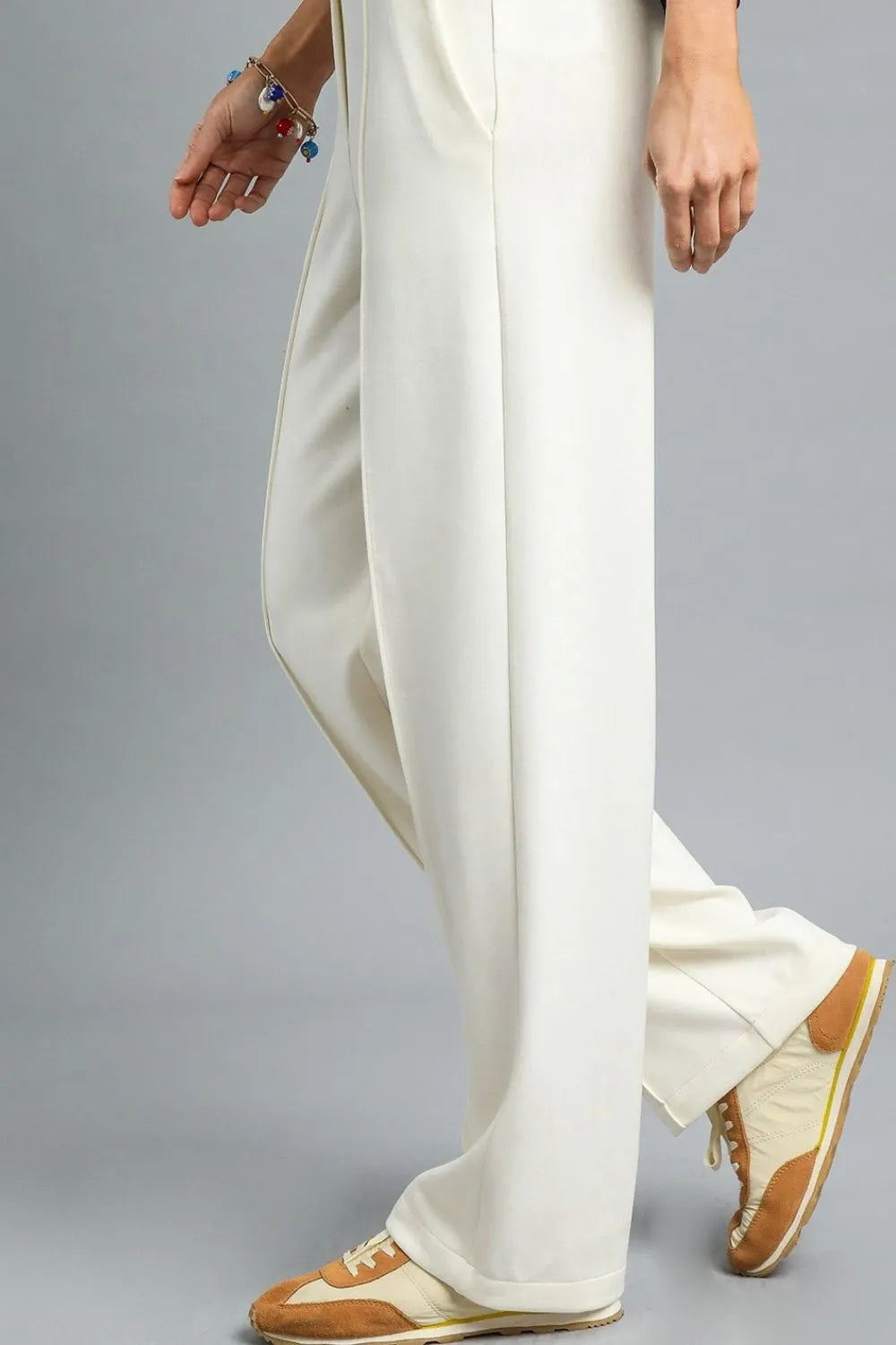 Cream high-waisted wide-leg pants in linen blend, modeled on a person walking.
