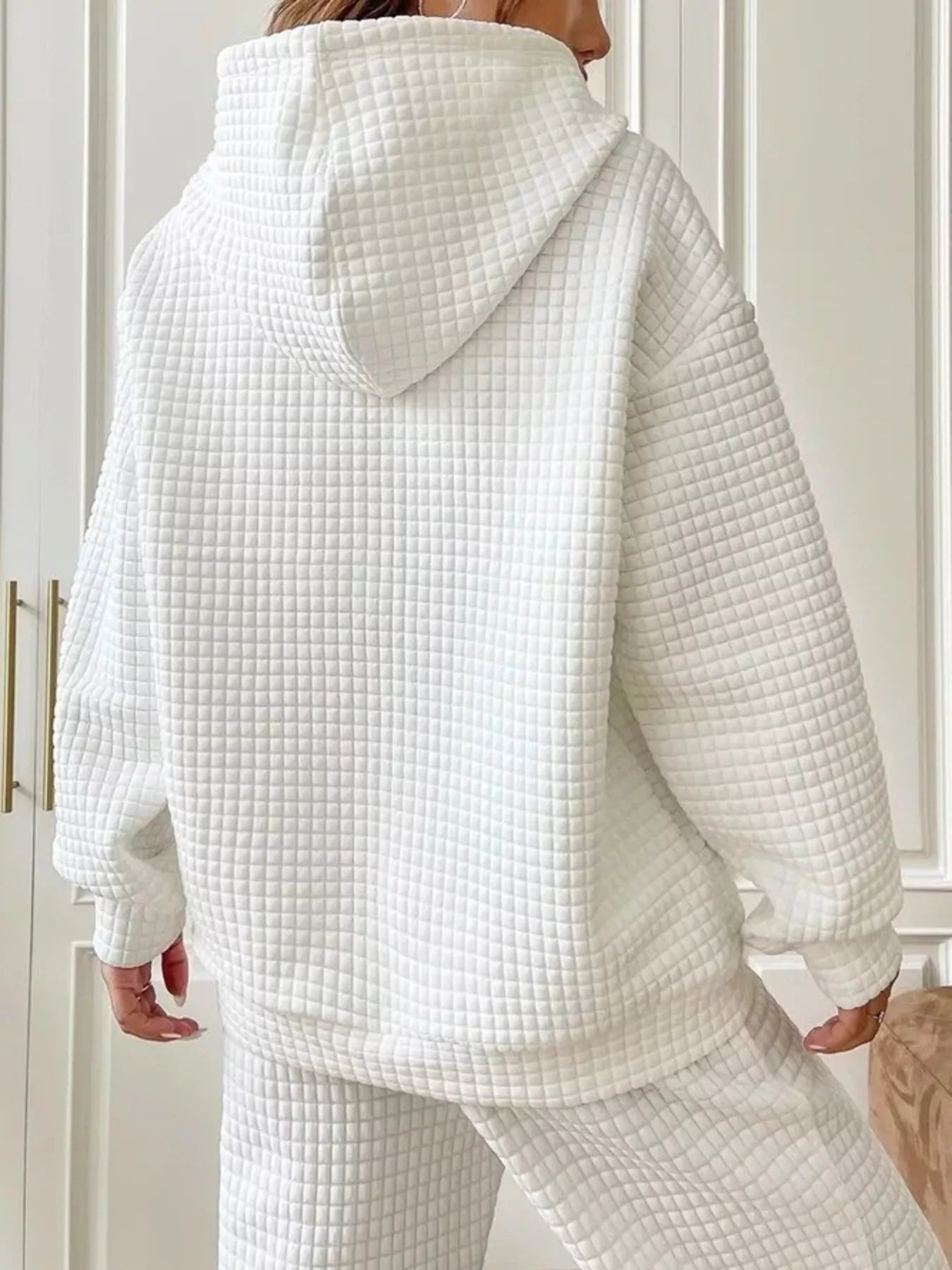 White waffle knit hoodie with drawstring hood and pockets, viewed from the back.